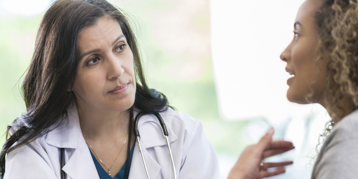 Woman explaining her symptoms to her doctor