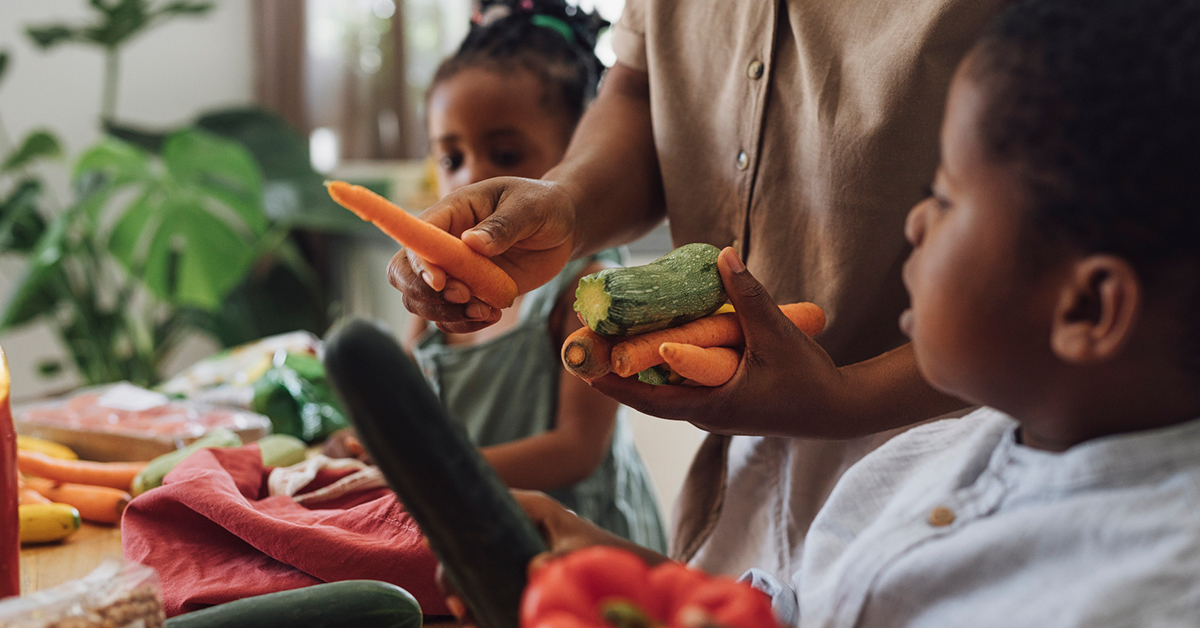 Two kids learning about vegetables in the kitchen